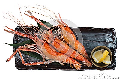 Isolated Top view of Grilled shrimps Giant Tiger Pawn with salt served with sliced lemon in black stone plate Stock Photo