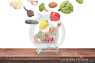 Isolated vegetables fall in basket on wooden table composition Stock Photo