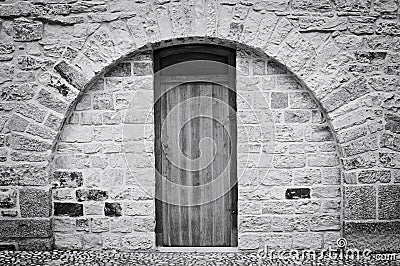 Isolated wooden door in a brick wall with a rounded arch Prague, Czech Republic Stock Photo