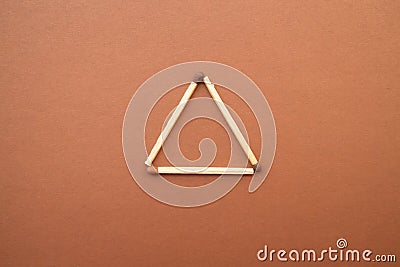 Isosceles triangle on a bright background. matchstick pyramid on cardboard. Education concept Stock Photo