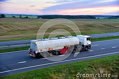 Isothermal Tank truck driving on highway. Oil and Gas Transportation and Logistics. Metal chrome cistern tanker with Stock Photo