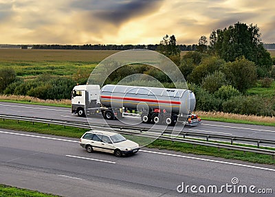 Isothermal Tank truck driving on highway. Oil and Gas Transportation and Logistics. Metal chrome cistern tanker with Stock Photo