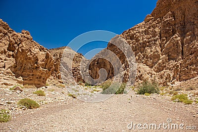 Israeli desert canyon passage way between sand stone rocky hills wasteland environment of Middle East Stock Photo