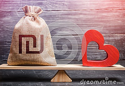 Israeli shekel money bag and red heart on scales. Funding healthcare. Health life insurance financing concept Stock Photo