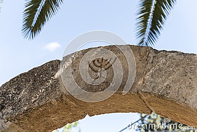 The Israeli symbol - Menorah - carved in stone on an arch at the entrance to the archaeological site of Tel Shilo in Samaria Editorial Stock Photo