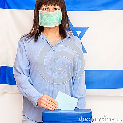 Israeli woman with face medical protected mask votes at a polling station on election day. Stock Photo