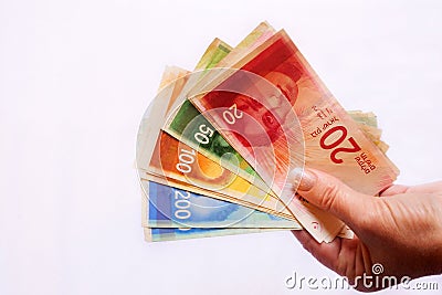 Israeli woman holding collection of different Bank of Israel bank notes denomination currency Stock Photo