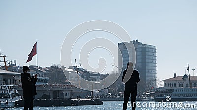 Istanbul bosphorus,sunny day. men are fishing on concrete port in Kadikoy shore and look at the marmara sea and transportation fer Editorial Stock Photo