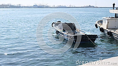 Istanbul kadikoy people fishing on concrete shore and small and old vintage fishing boat on bosporus istanbul near haydarpasa main Stock Photo