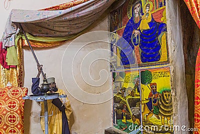 Priest showing colorful paintings in the Old Church of St Mary of Zion in Axum, Ethiop Editorial Stock Photo