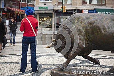 Funny moment of young woman and bull statue at Kadikoy Editorial Stock Photo