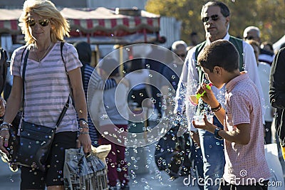 Istanbul, Turkey - September-28,2019: Child selling bubble machine on the street and little soap bubbles around. Blurred people Editorial Stock Photo