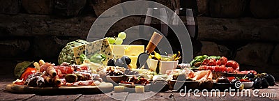 Italian antipasti wine snacks set. Cheese variety, Mediterranean olives, crudo, Prosciutto di Parma, salami and wine in glasses Stock Photo