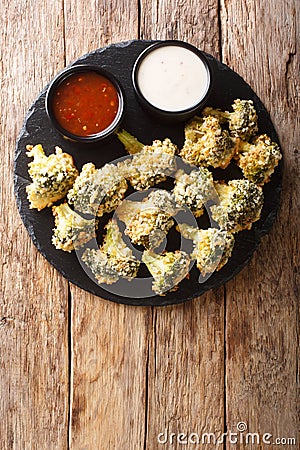 Italian baked broccoli appetizer with parmesan served with sauces. Vertical top view Stock Photo