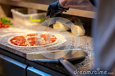 Italian chief-cooker baking pizza in the restaurant Stock Photo