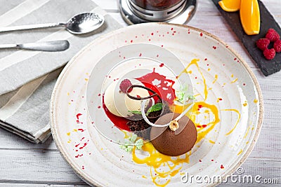 Italian Colorful ice cream scoops semifreddo with chocolate and raspberry on white plate Stock Photo