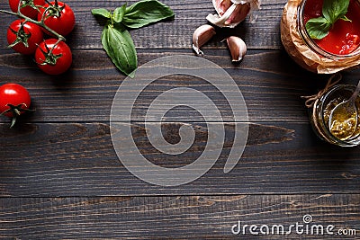 Italian Cuisine. Tomato, basil, garlic and tomato sauce on the dark wooden table top view, with copy space Stock Photo