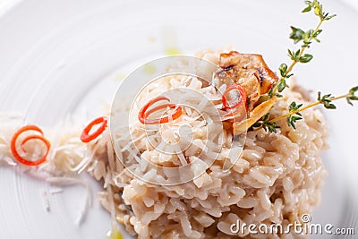 Italian dish risotto with wild white mushrooms and Parmesan cheese in a white plate. Mediterranean restaurant menu Stock Photo