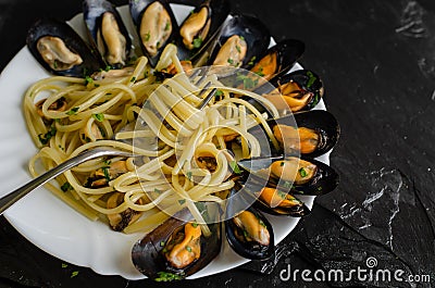 Italian dish with steamed mussels with wine. Close up of spaghetti on a fork. Seafood eating concept. Stock Photo