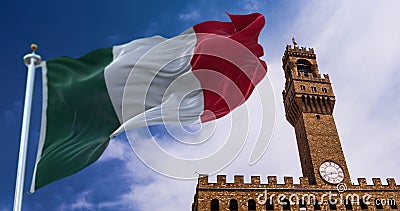 The Italian flag waving in the wind with the tower of Palazzo Vecchio in Florence in the background Stock Photo