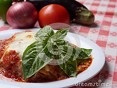 Italian food combination of lasagna, small side salad and garlic knots with whole raw vegetables on the background Stock Photo