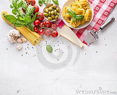 Italian food cuisine and ingredients on white concrete table. Spaghetti Tagliatelle olives olive oil tomatoes parmesan cheese. Stock Photo