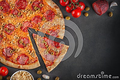 Italian homamade pizza with one piece and ingredients. Italian pizza on a dark gray black background Stock Photo