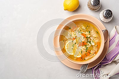 Italian lemon chicken orzo soup in bowl on concrete background Stock Photo