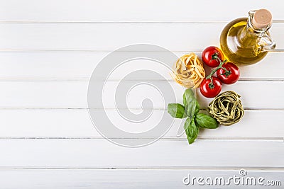 Italian and Mediterranean food ingredients on wooden background.Cherry tomatoes pasta, basil leaves and carafe with olive oil. Stock Photo