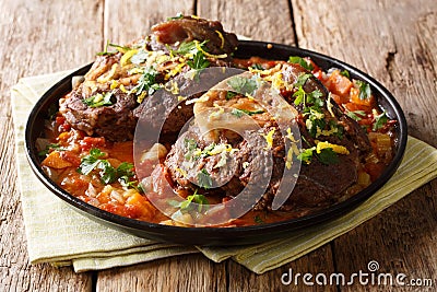 Italian menu: braised veal steak Ossobuco alla Milanese with gremolata and vegetable sauce close-up. horizontal Stock Photo