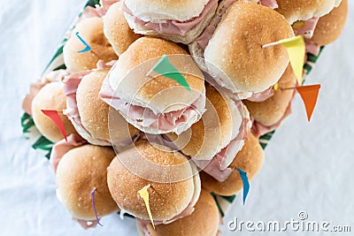 Italian party panini piled in stack in finger food style. Small panini sandwich with ham and salami. Italian food birthday party Stock Photo