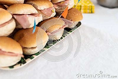 Italian party panini piled in stack in finger food style. Small panini sandwich with ham and salami. Italian food birthday party Stock Photo