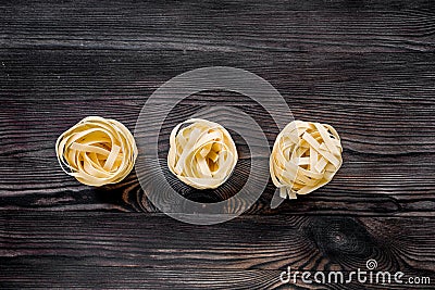 Italian pasta fettuccine nest on grey wooden table top view copyspace Stock Photo