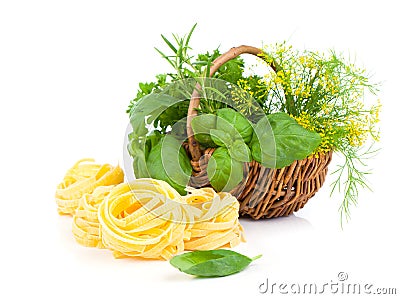 Italian pasta fettuccine nest with wicker basket green herbs Stock Photo