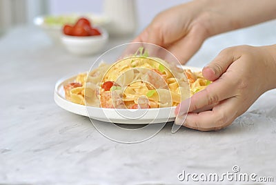 Italian pasta fettuccine with shrimps in white bowl on gray table. Close up beautiful picture homemade national cuisine Stock Photo