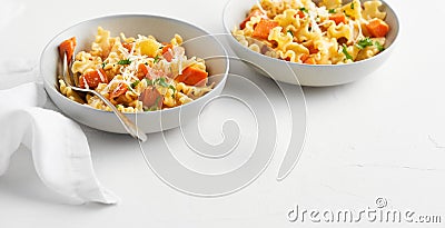 Italian pasta Mafalda Corta trafilata al bronzo with sauteed sweet potato, fennel, parmesan grated cheese on white background. Stock Photo