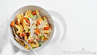 Italian pasta Mafalda Corta trafilata al bronzo with sauteed sweet potato, fennel, parmesan grated cheese on white background. Stock Photo