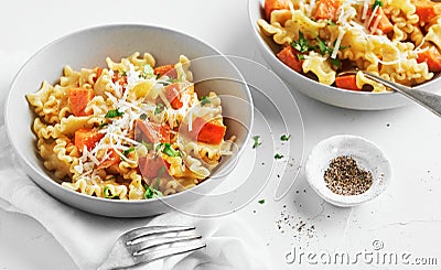 Italian pasta Mafalda Corta trafilata al bronzo with sauteed sweet potato, fennel, parmesan grated cheese on white background. Stock Photo