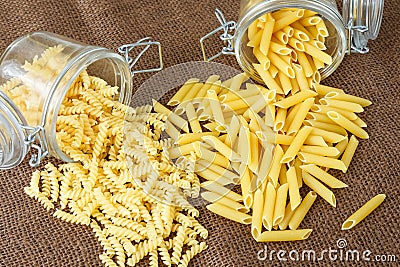 Italian pasta - penne and fusilli in glass jar Stock Photo