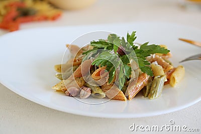 Italian pasta with pistachios in a triangular white plate Stock Photo