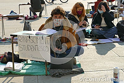 Italian students protest against the government`s choice to close schools by following remote lessons on the sidewalk Editorial Stock Photo