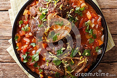 Italian veal steak Ossobuco alla Milanese with gremolata and spicy sauce closeup. horizontal top view Stock Photo