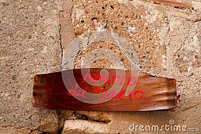 Italian vintage wood signboard hanging on a tufa wall. translation: Stock Photo