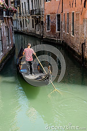 Italy, Venice, Gondolier navigating a gondola near San Moise on a canal Editorial Stock Photo