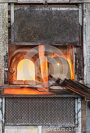 Italy, Venice, Murano glass factory special glass-blowing tools: red-hot furnace with fire to make the glass malleable, and iron Stock Photo