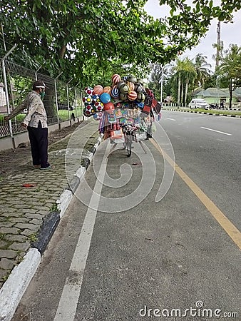 itinerant children& x27;s toy seller. Using bicycle. Editorial Stock Photo