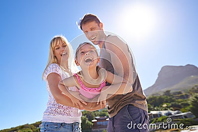 Its a family getaway. a happy young family being playful at the beach. Stock Photo