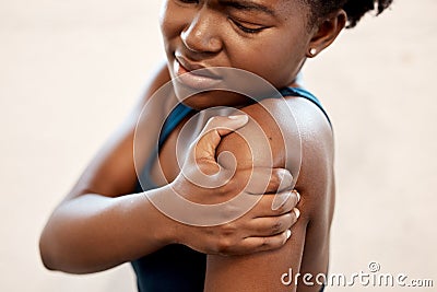 Its far too painful to train like this. a sporty young woman experiencing shoulder pain while exercising in a gym. Stock Photo