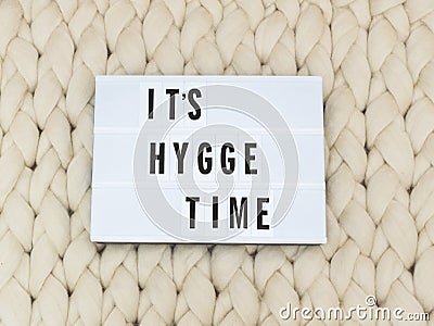 ITS HYGGE TIME word on lightbox on knit background. Cozy compozition. Knit background. Stock Photo