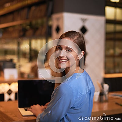 Its the perfect place to blog. Cropped portrait of an attractive young woman blogging in her local coffee shop. Stock Photo